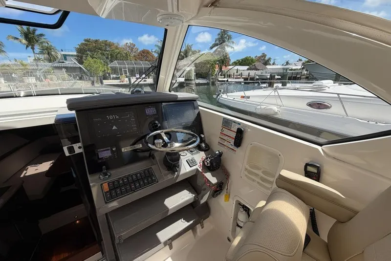 Slide: The Image of 2018 Pursuit OS 355 Offshore helm with modern controls and waterfront view. - 16