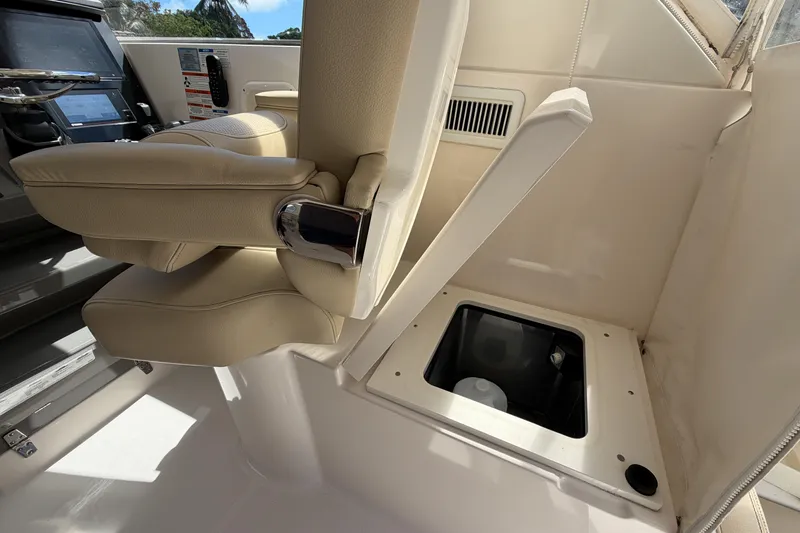 Slide: The Image of 2018 Pursuit OS 355 Offshore helm seat and storage compartment. - 17