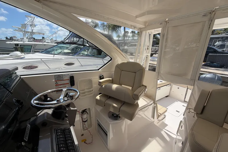 Slide: The Image of 2018 Pursuit OS 355 Offshore boat interior with helm and seating area. - 18