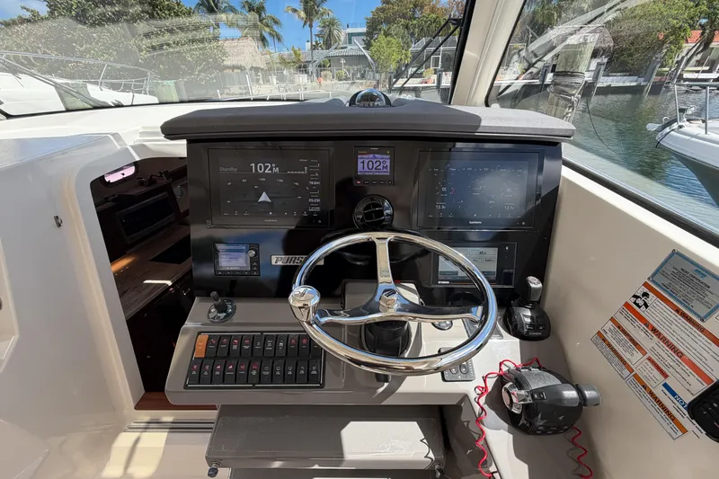 Slide: The Image of Helm of 2018 Pursuit OS 355 Offshore boat with modern navigation controls and steering wheel. - 19
