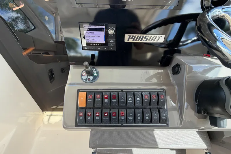 Slide: The Image of Control panel of a 2018 Pursuit OS 355 Offshore boat with switches and joystick. - 20
