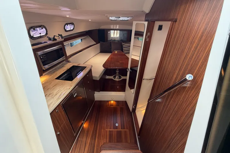 Slide: The Image of Luxurious interior of a 2018 Pursuit OS 355 Offshore boat with modern kitchen and seating area. - 24