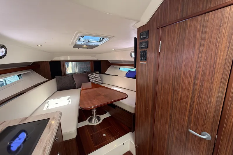 Slide: The Image of 2018 Pursuit OS 355 Offshore cabin interior with wood finish and seating area. - 26