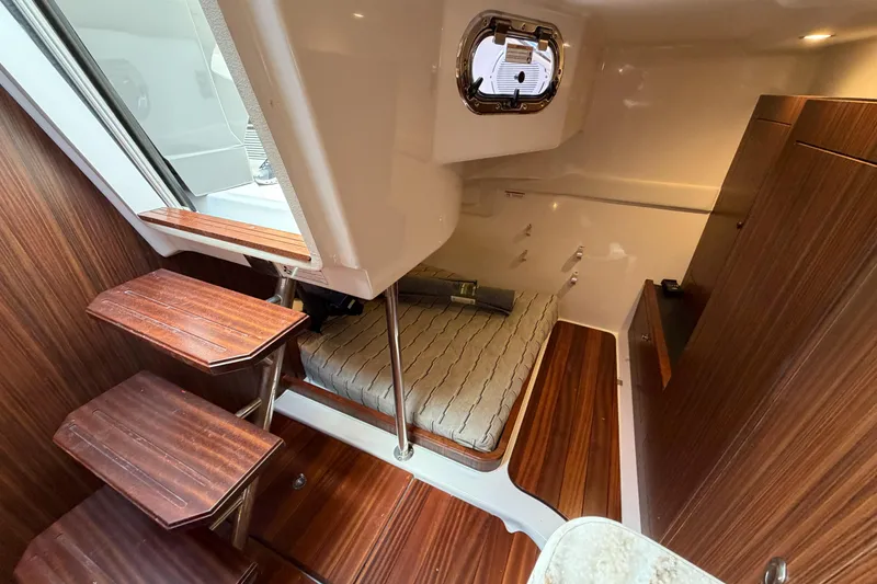 Slide: The Image of 2018 Pursuit OS 355 Offshore cabin interior with wooden steps and cozy bed. - 28