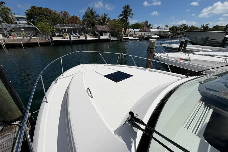 Slide: The Image of 2018 Pursuit OS 355 Offshore boat docked in a scenic marina with palm trees. - 30