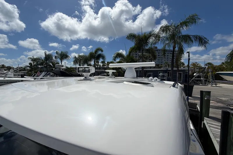 Slide: The Image of 2018 Pursuit OS 355 Offshore boat docked under a sunny sky with palm trees. - 32