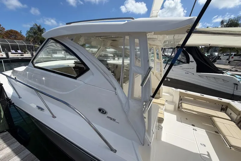 Slide: The Image of 2018 Pursuit OS 355 Offshore boat docked under a clear blue sky. - 4