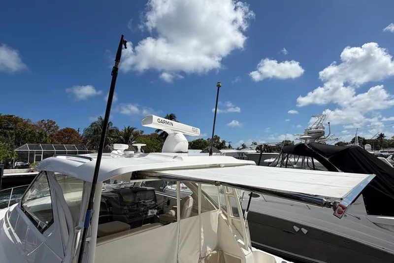 Slide: The Image of 2018 Pursuit OS 355 Offshore boat with Garmin radar, docked under a clear blue sky. - 5
