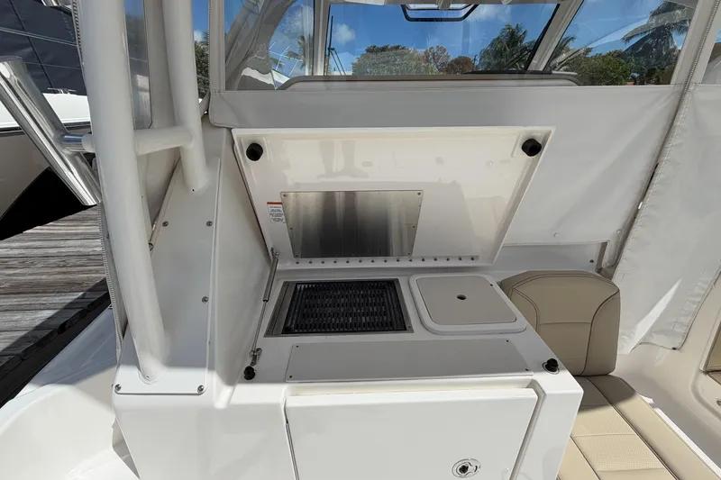Slide: The Image of 2018 Pursuit OS 355 Offshore boat interior with kitchenette and seating area. - 7