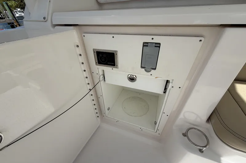 Slide: The Image of 2018 Pursuit OS 355 Offshore boat storage compartment with electrical panel and outlet. - 8