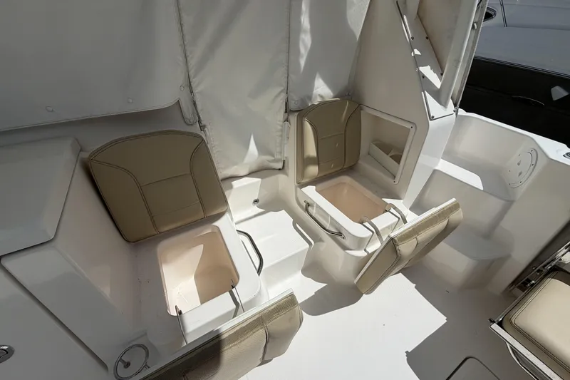 Slide: The Image of 2018 Pursuit OS 355 Offshore boat interior with beige seating and storage compartments. - 9