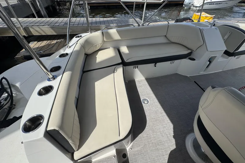 Slide: The Image of 2022 Stingray 192 SC boat interior with cushioned seating and cup holders. - 15
