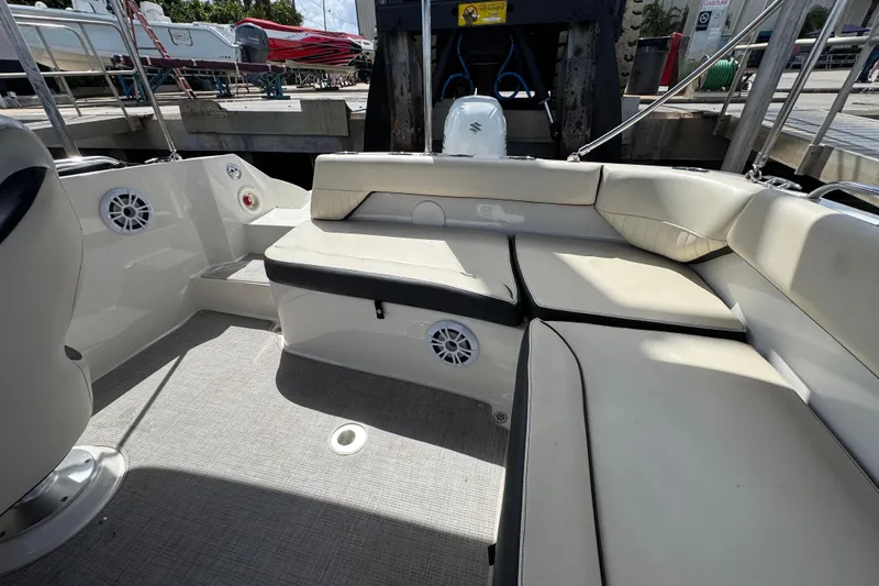 Slide: The Image of Interior of a 2022 Stingray 192 SC boat with beige seating and speakers. - 17