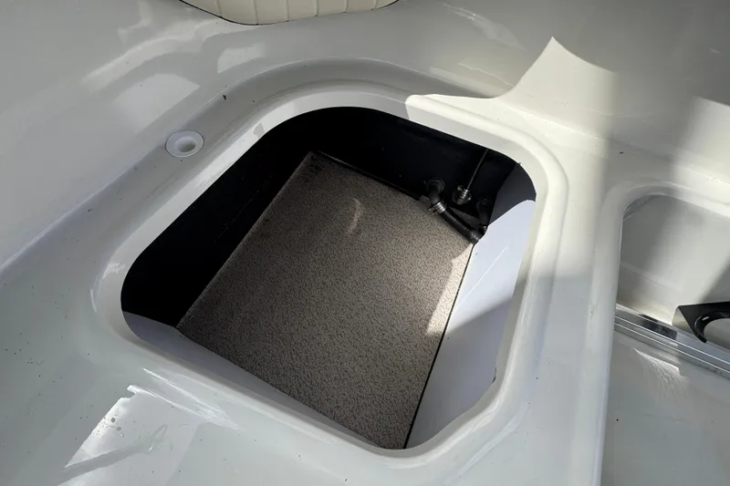 Slide: The Image of 2022 Stingray 192 SC boat storage compartment with carpeted interior. - 20