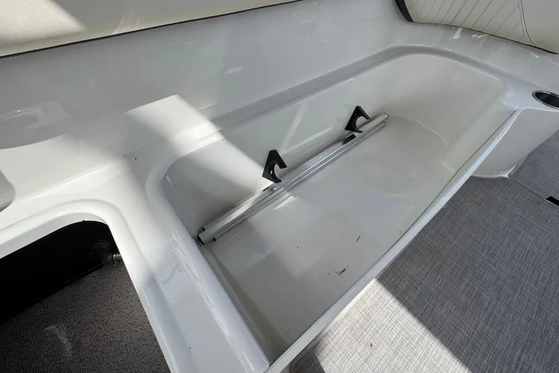 Slide: The Image of 2022 Stingray 192 SC boat interior storage compartment with sleek white finish. - 21