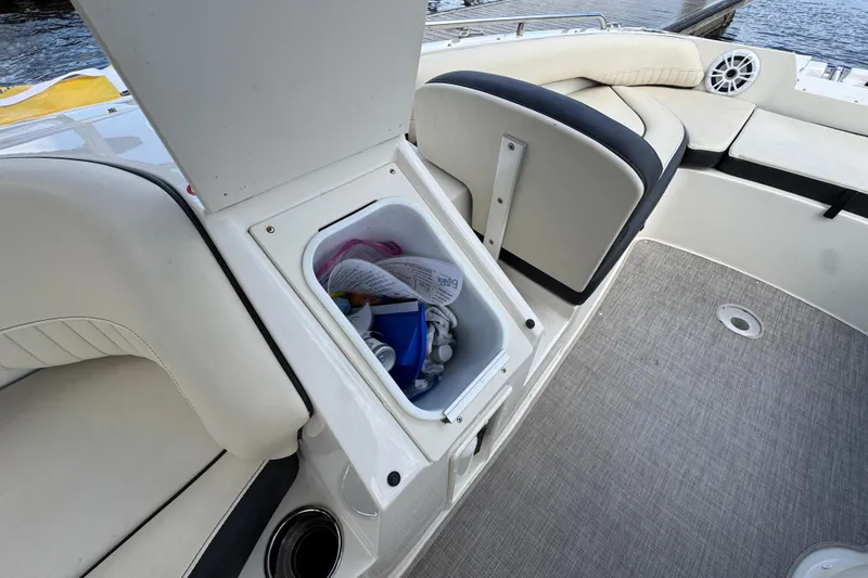Slide: The Image of Open storage compartment on 2022 Stingray 192 SC boat, showing interior items and seating area. - 23