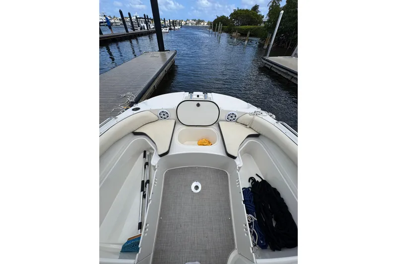 Slide: The Image of 2022 Stingray 192 SC boat interior at dock, featuring spacious seating and storage. - 28
