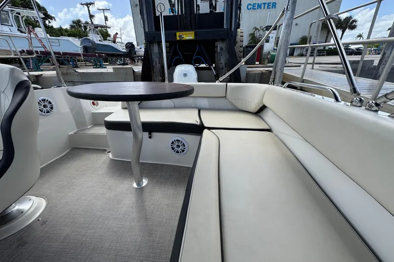 Slide: The Image of 2022 Stingray 192 SC boat interior with seating and table, docked at marina. - 31