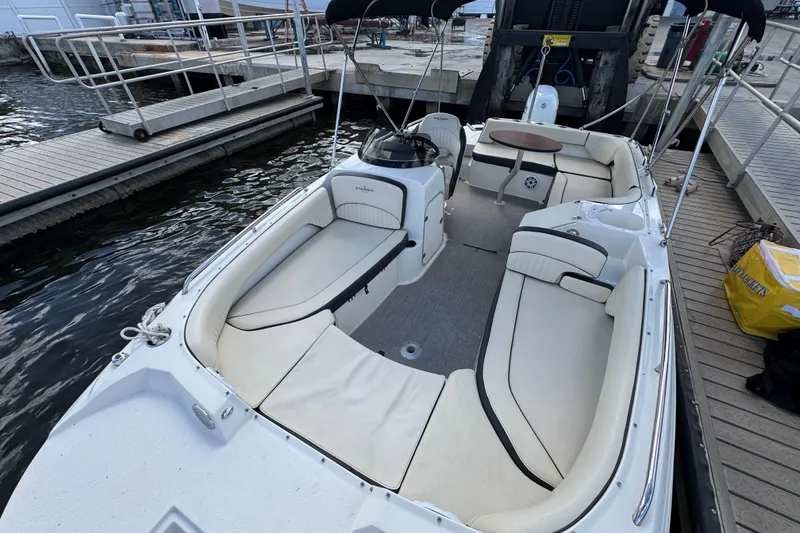 Slide: The Image of 2022 Stingray 192 SC boat interior with white seating, docked at marina. - 33
