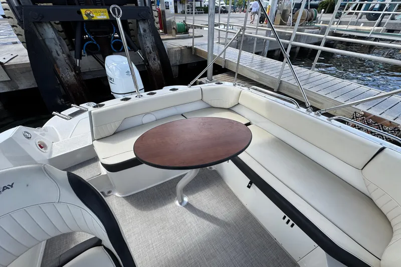 Slide: The Image of 2022 Stingray 192 SC boat interior with seating and table at dockside. - 35