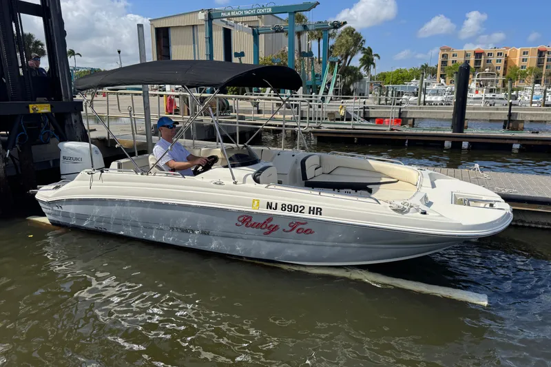 Slide: The Image of 2022 Stingray 192 SC boat docked at marina, featuring canopy and Suzuki engine. - 4