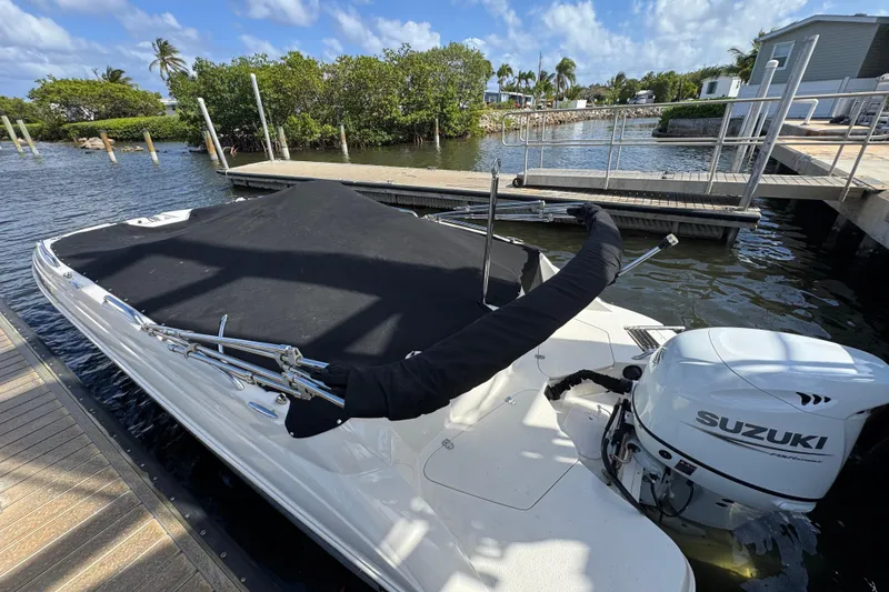 Slide: The Image of 2022 Stingray 192 SC boat with Suzuki outboard motor docked by the water. - 40