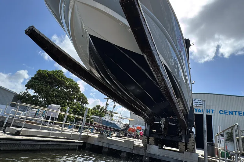 Slide: The Image of 2022 Stingray 192 SC boat being lifted at a yacht center under a clear sky. - 42
