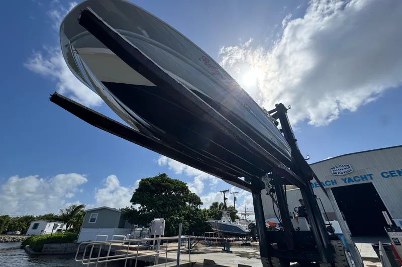 Slide: The Image of 2022 Stingray 192 SC boat lifted at marina under bright sky. - 43