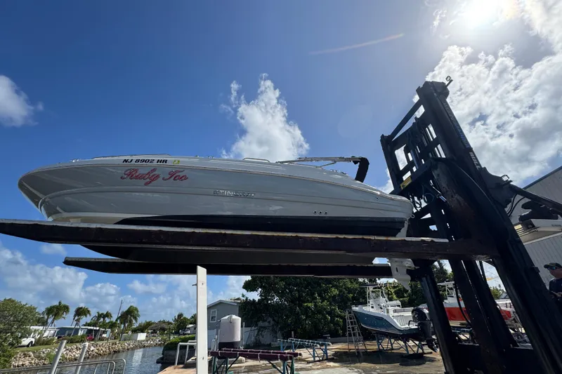 Slide: The Image of 2022 Stingray 192 SC boat lifted by forklift under a clear blue sky. - 44