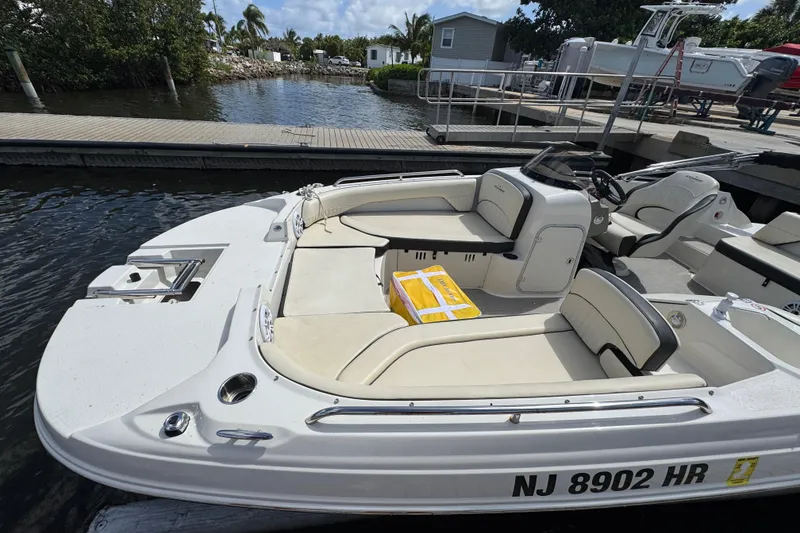Slide: The Image of 2022 Stingray 192 SC boat docked, featuring spacious seating and sleek design. - 5