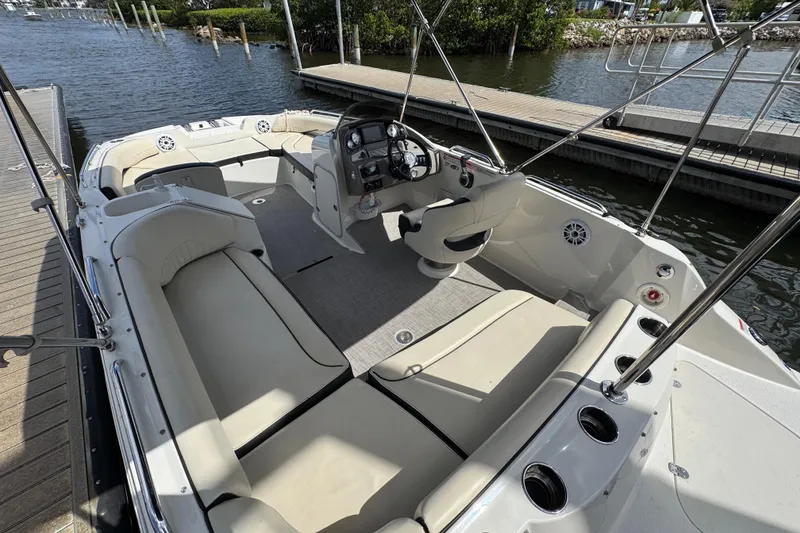 Slide: The Image of 2022 Stingray 192 SC boat interior with spacious seating and modern dashboard, docked by the water. - 8