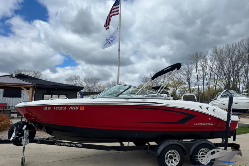 The Image of 2017 Chaparral 21 H2O Sport boat on trailer, red and white, parked outdoors. - 0