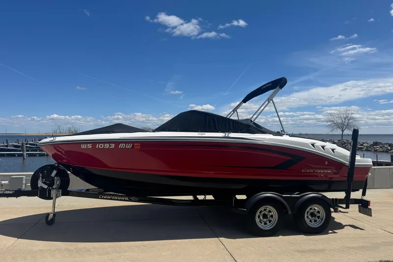 Slide: The Image of 2017 Chaparral 21 H2O Sport boat on trailer by waterfront under blue sky. - 12