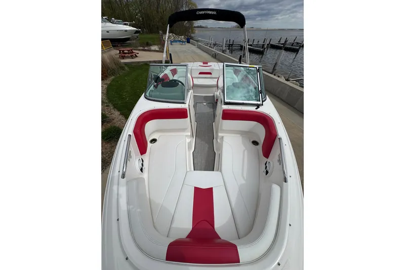 Slide: The Image of 2017 Chaparral 21 H2O Sport boat with red and white interior, docked by the water. - 17
