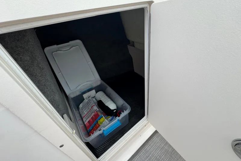 Slide: The Image of Storage compartment in 2017 Chaparral 21 H2O Sport boat with organized supplies. - 21