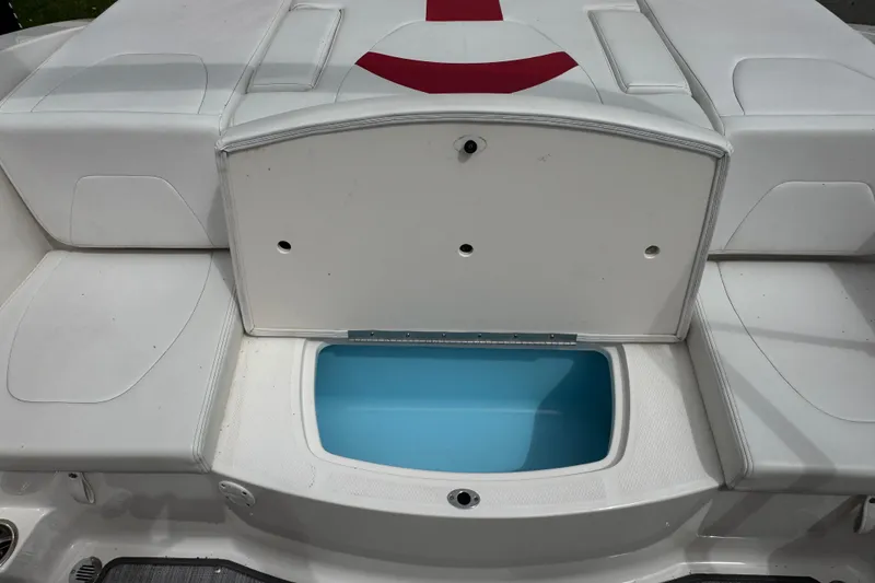 Slide: The Image of 2017 Chaparral 21 H2O Sport boat with open storage compartment and white seating. - 33