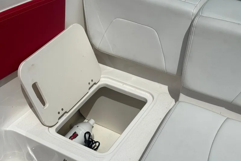 Slide: The Image of 2017 Chaparral 21 H2O Sport boat storage compartment with open lid and visible equipment. - 34
