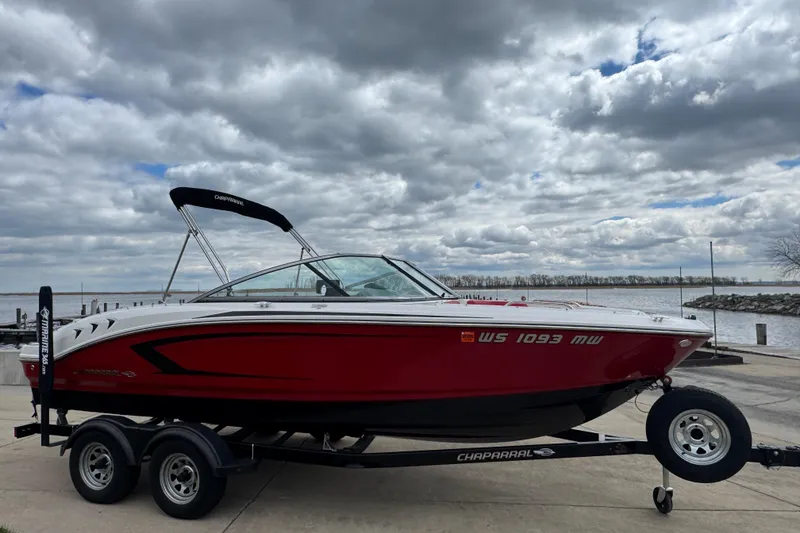 Slide: The Image of 2017 Chaparral 21 H2O Sport boat on trailer by a lake under cloudy sky. - 5