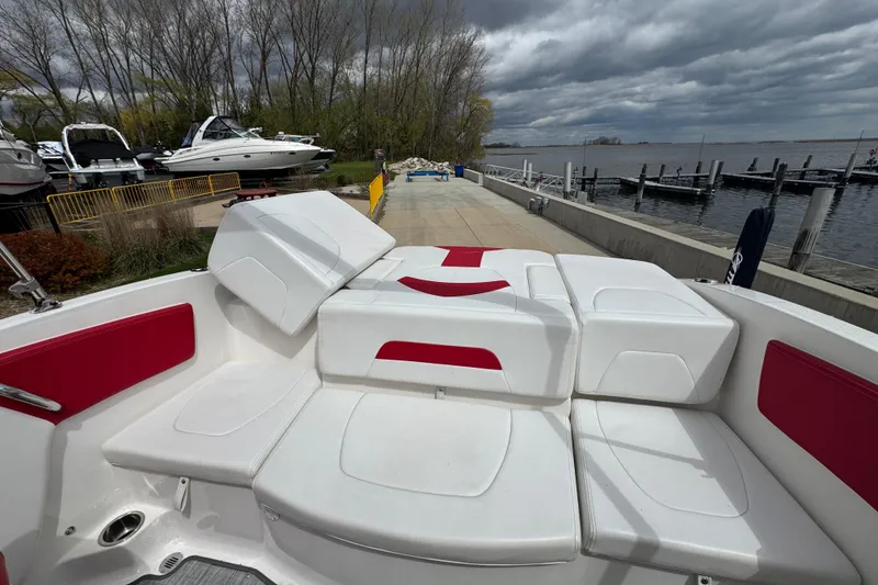 Slide: The Image of 2017 Chaparral 21 H2O Sport boat with red and white seating, docked by a marina. - 8
