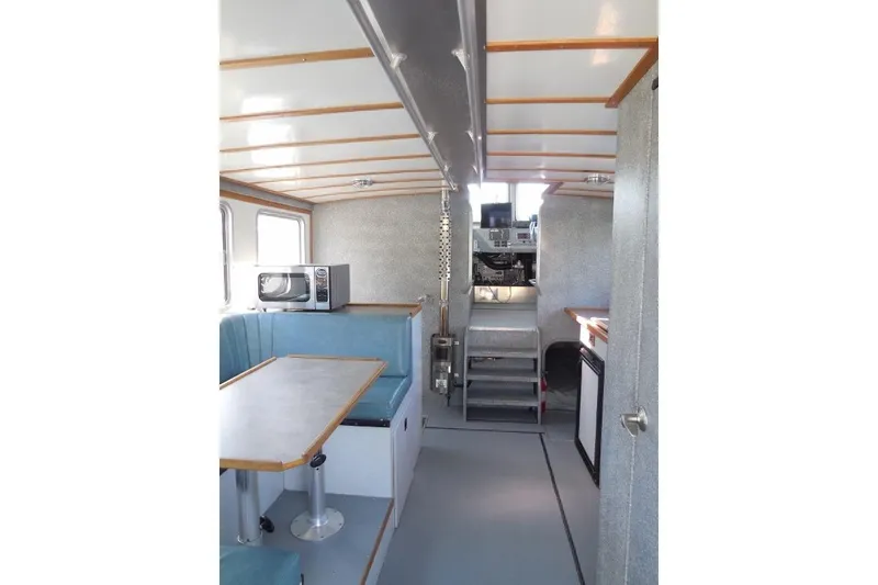 Slide: The Image of Interior of 2007 Armstrong Marine 36 Catamaran with seating, table, and microwave. - 10
