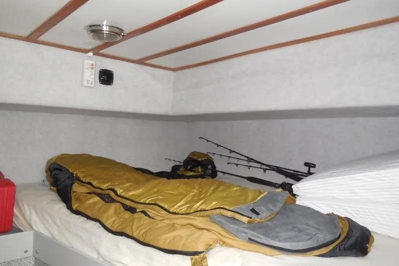 Slide: The Image of Interior cabin of 2007 Armstrong Marine 36 Catamaran with sleeping bag and fishing rods. - 20