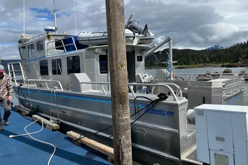 Slide: The Image of 2007 Armstrong Marine 36 Catamaran docked, featuring aluminum hull and scenic background. - 21