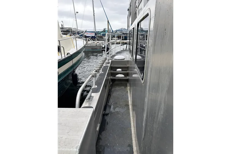 Slide: The Image of 2007 Armstrong Marine 36 Catamaran docked, side view with visible railings and windows. - 24