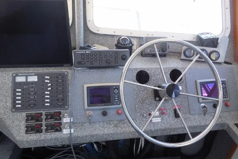 Slide: The Image of Control panel of a 2007 Armstrong Marine 36 Catamaran with steering wheel and navigation equipment. - 3