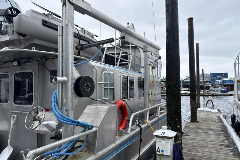 Slide: The Image of 2007 Armstrong Marine 36 Catamaran docked at marina, featuring safety equipment and utility lines. - 30