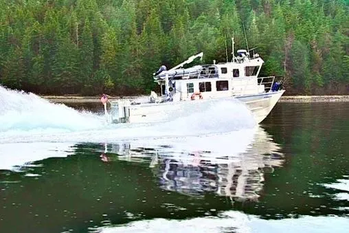Slide: The Image of 2007 Armstrong Marine 36 Catamaran cruising on a forest-lined waterway. - 34