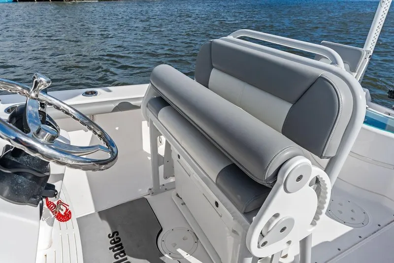 Slide: The Image of 2023 Everglades 243 Center Console boat interior with steering wheel and seating, on water. - 30