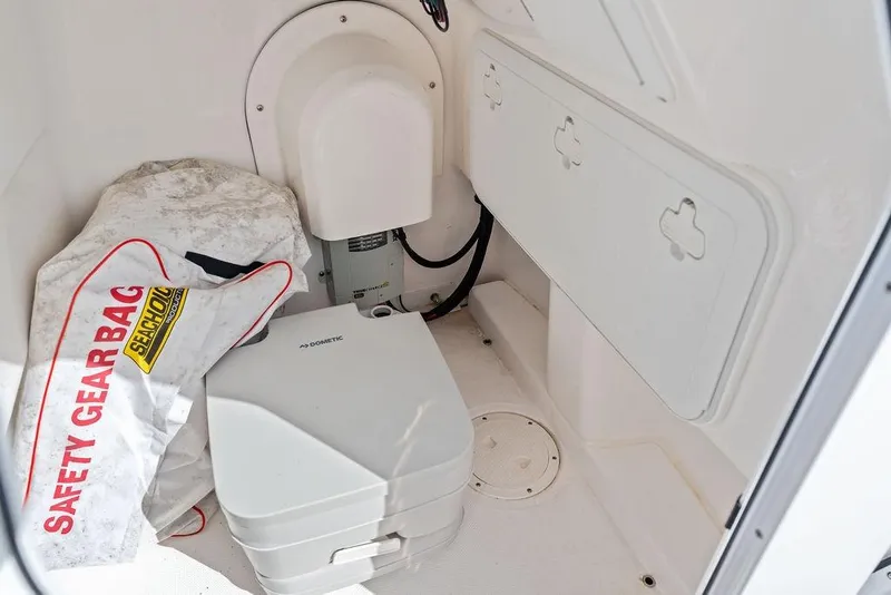 Slide: The Image of Interior of 2023 Everglades 243 Center Console with safety gear and portable toilet. - 34