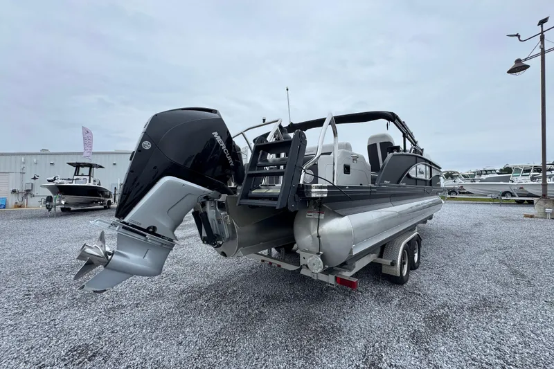 Slide: The Image of 2023 Barletta CORSA 25UC pontoon boat on trailer, featuring Mercury outboard engine. - 11