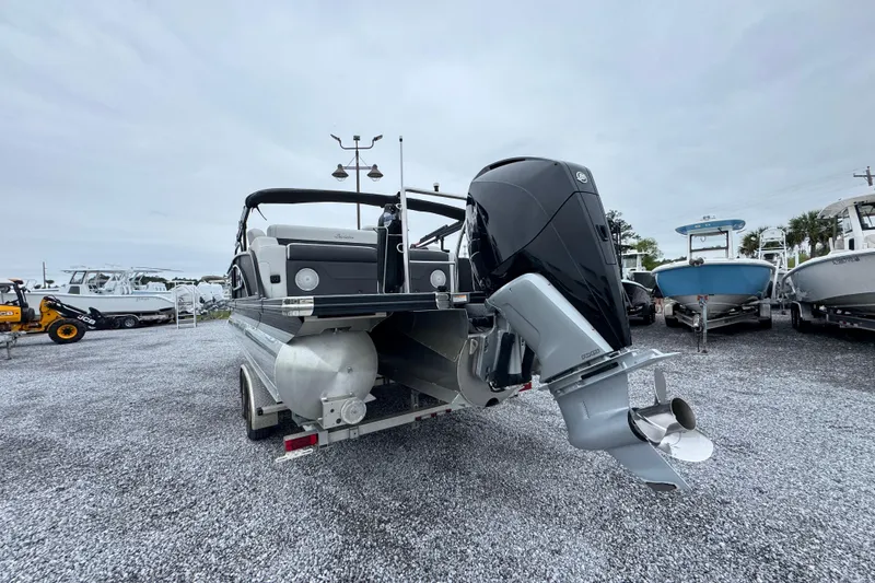 Slide: The Image of 2023 Barletta CORSA 25UC pontoon boat with powerful outboard motor, displayed on gravel lot. - 13